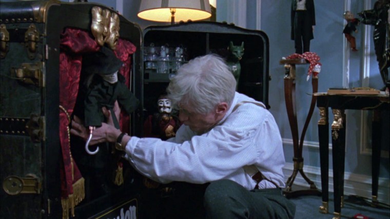 The bored puppets make him perform sexual favours on them to pass the time. Okay, not really